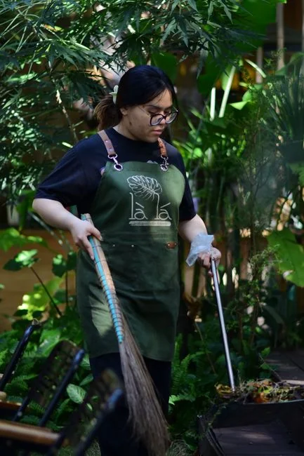 team-03 A professional cleaner in protective gear vacuuming the floor in a modern living room.